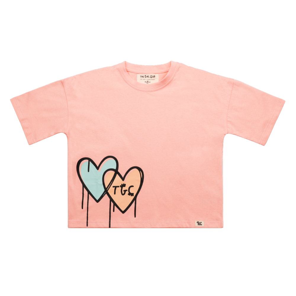 Pink t-shirt with heart designs and 'TGC' text on a white background