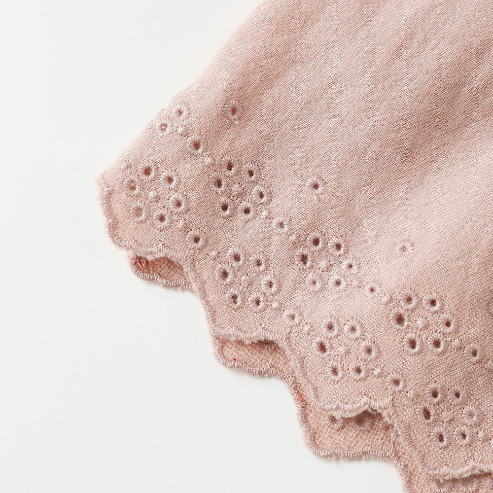 Pink fabric with eyelet trim on a white background