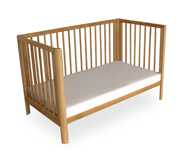 Wooden crib with a white mattress on a white background