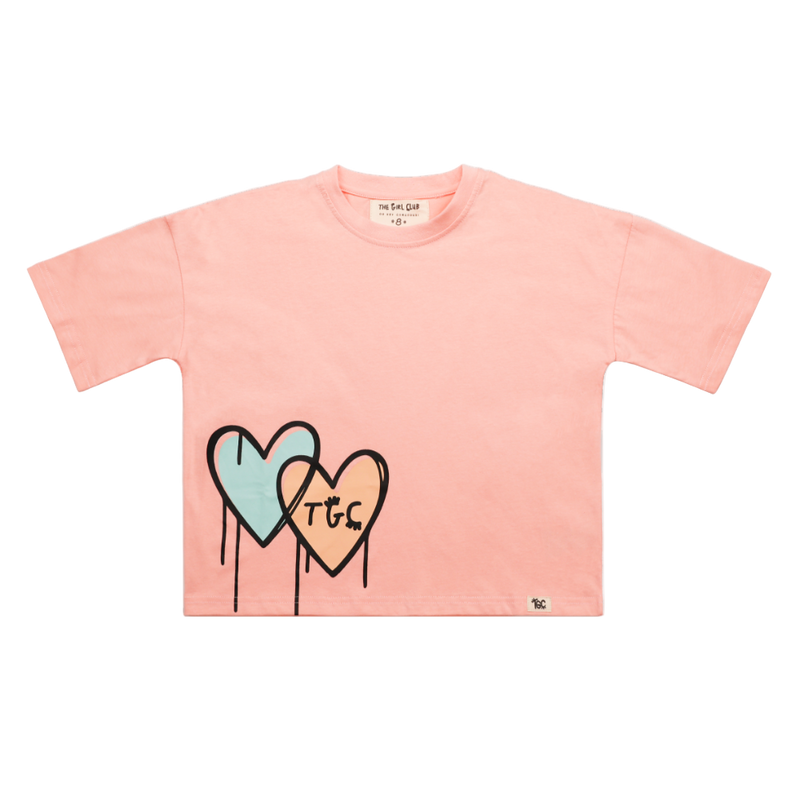 Pink t-shirt with heart designs and 'TGC' text on a white background