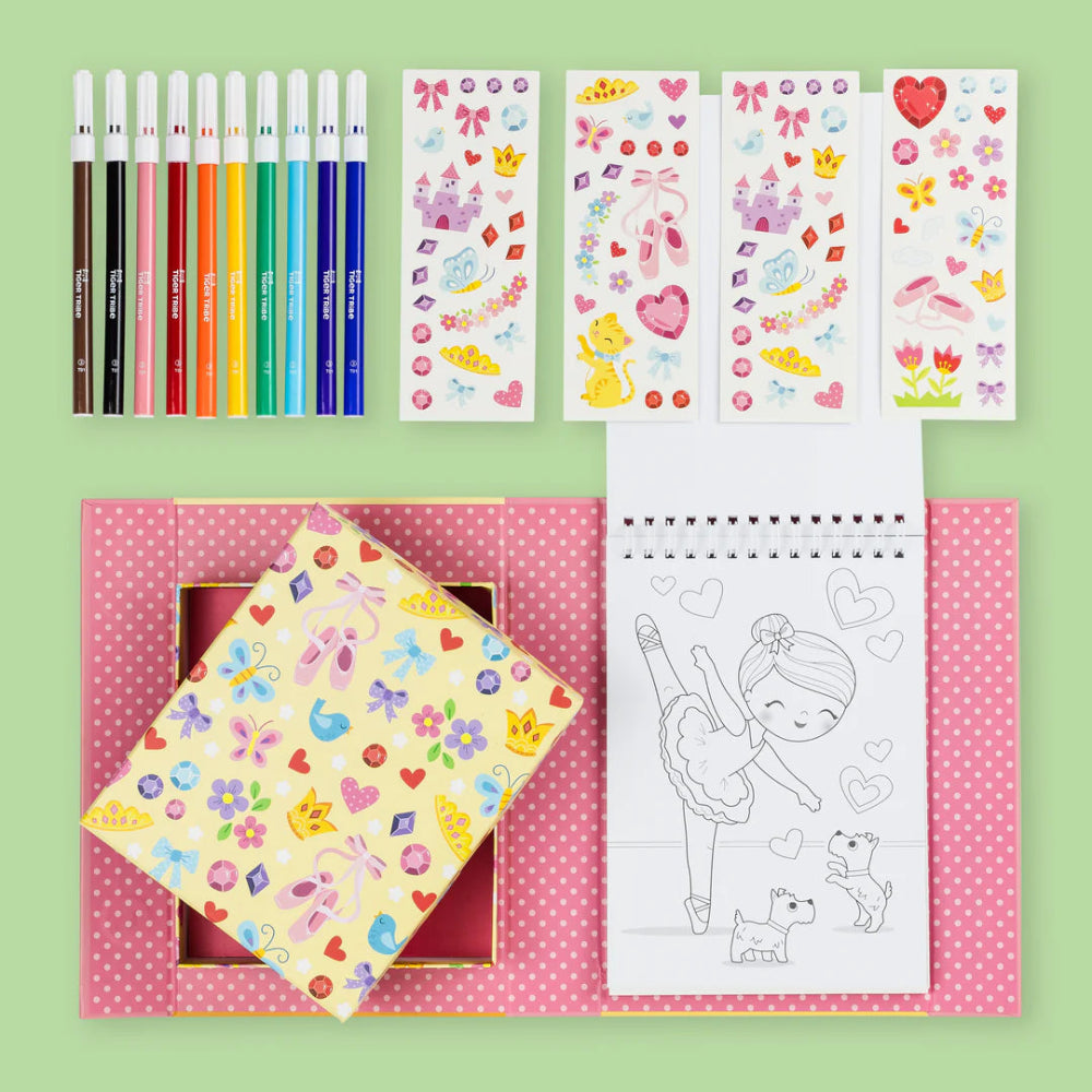 Coloring book, pencils, and stickers on a green background