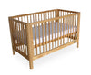Wooden crib with a white mattress on a white background