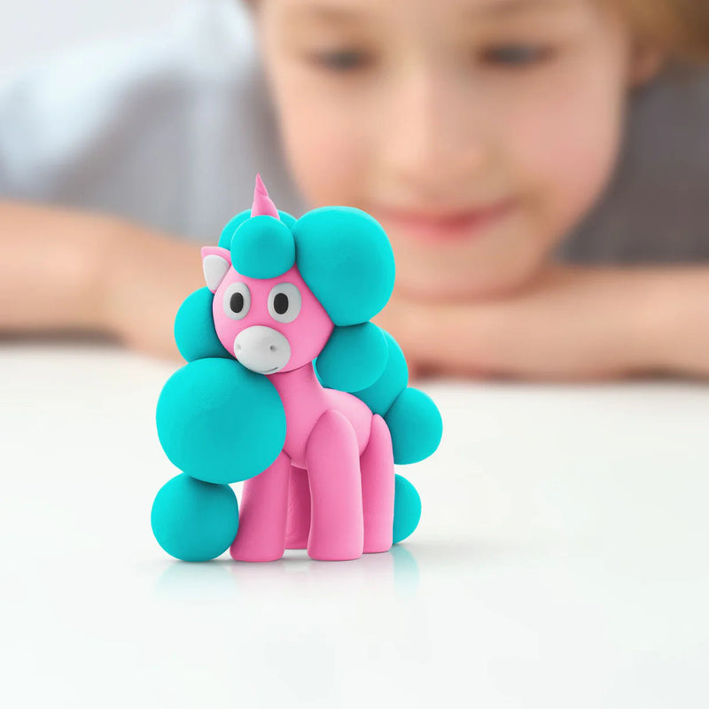 Pink and blue unicorn figurine with a child in the background